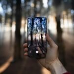 person holding black smartphone taking photo of city lights during night time