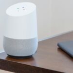 white and gray Google home on brown table